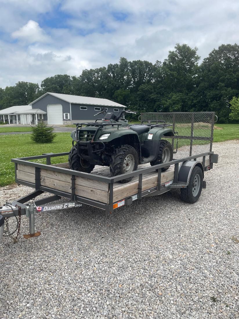 Utility trailer loaded with a four-wheeler for rental